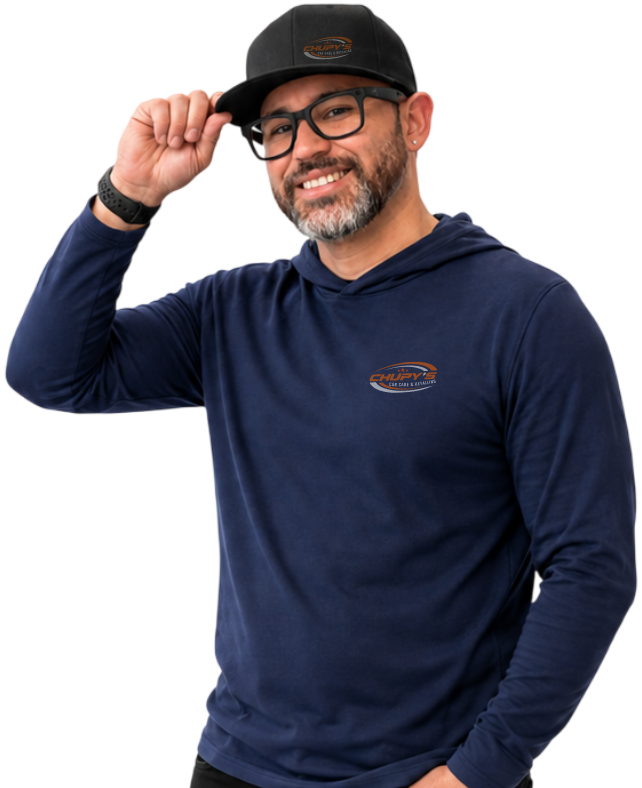 hombre con una gorra agarrándola con su mano y sonriendo a la camara